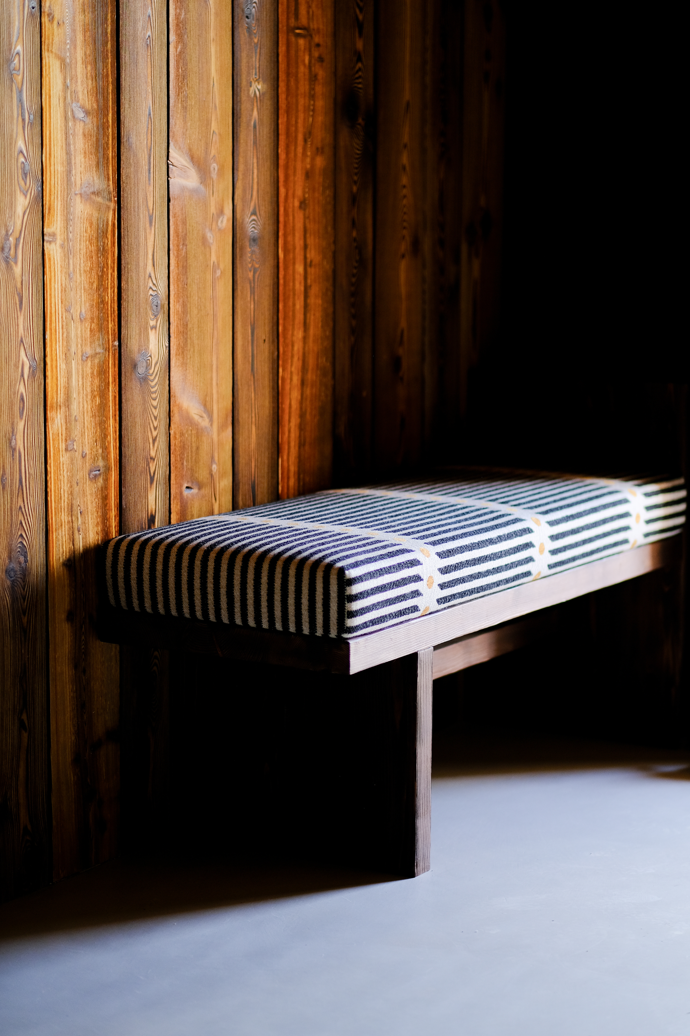Banquette en bois et tissu rayé dans un chalet à Megève